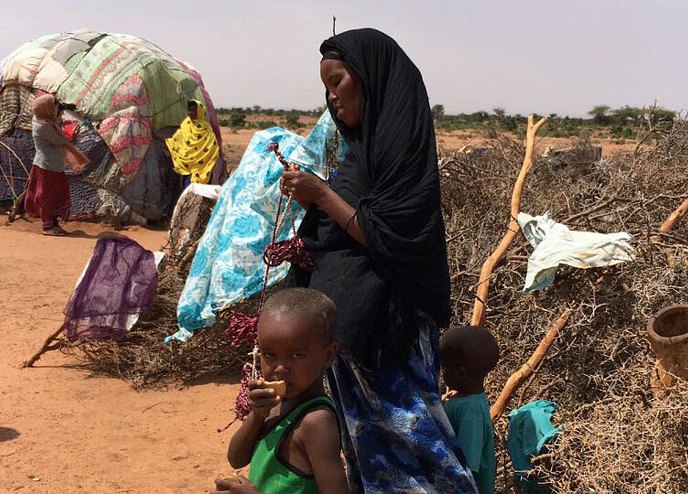 Somalierin und Kind vor Hütte