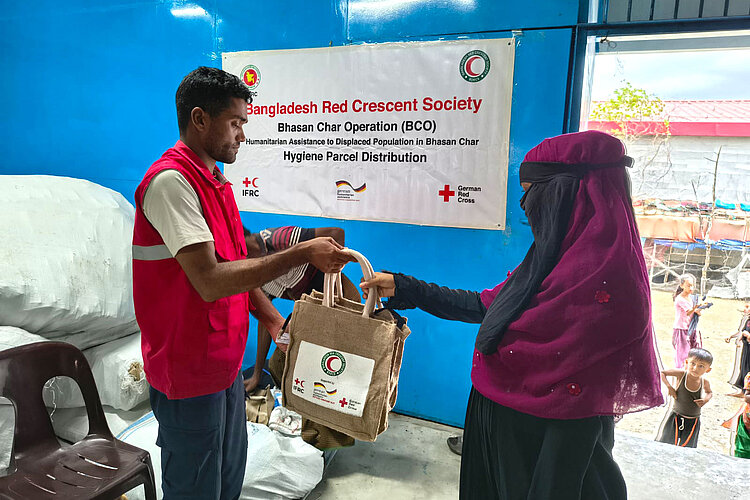 Helfer gibt Beutel an Frau