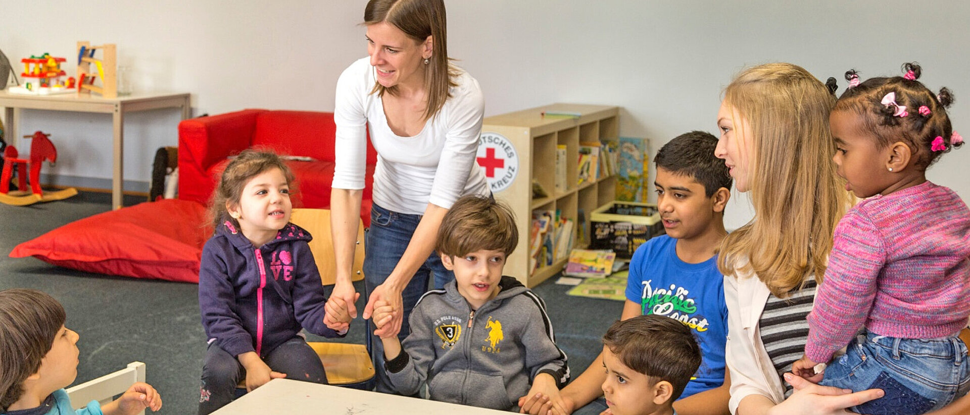 Frau mit Kindern in einer Kita 