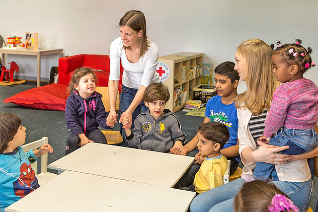 Frau mit Kindern in einer Kita 