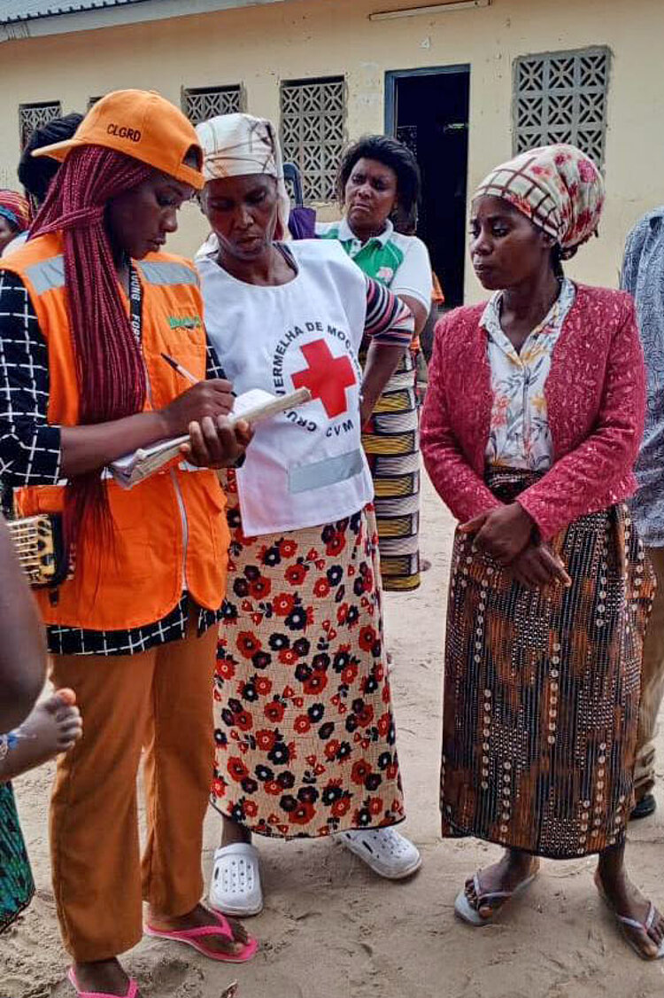 Gespräch mit Freiwiliger Freiwilige spricht mit zwei Frauen