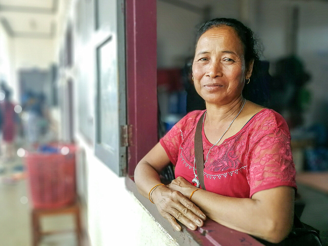 Laotische Frau schaut aus Fenster