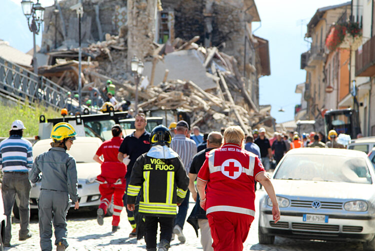 Rotkreuz-Helfer vor Trümmern nach Erdbeben