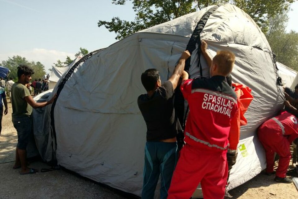 Helfer des Roten Kreuzes von Bosnien und Herzegowina helfen beim Zeltaufbau im Lager Vuçjak