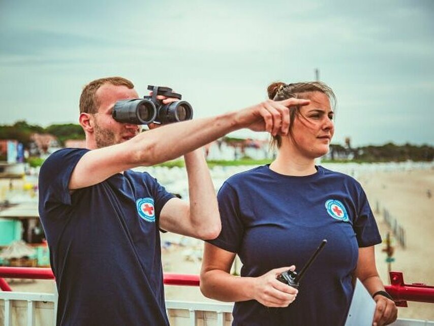 Wasserwacht an der Ostsee in Mecklenburg-Vorpommern: Helfer mit Fernglas und Walkie-Talkie