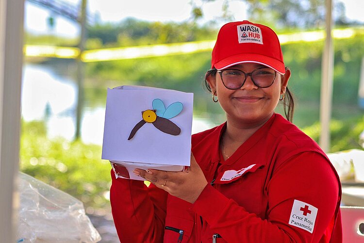 Rotkreuzlerin hält Grafik von Moskito