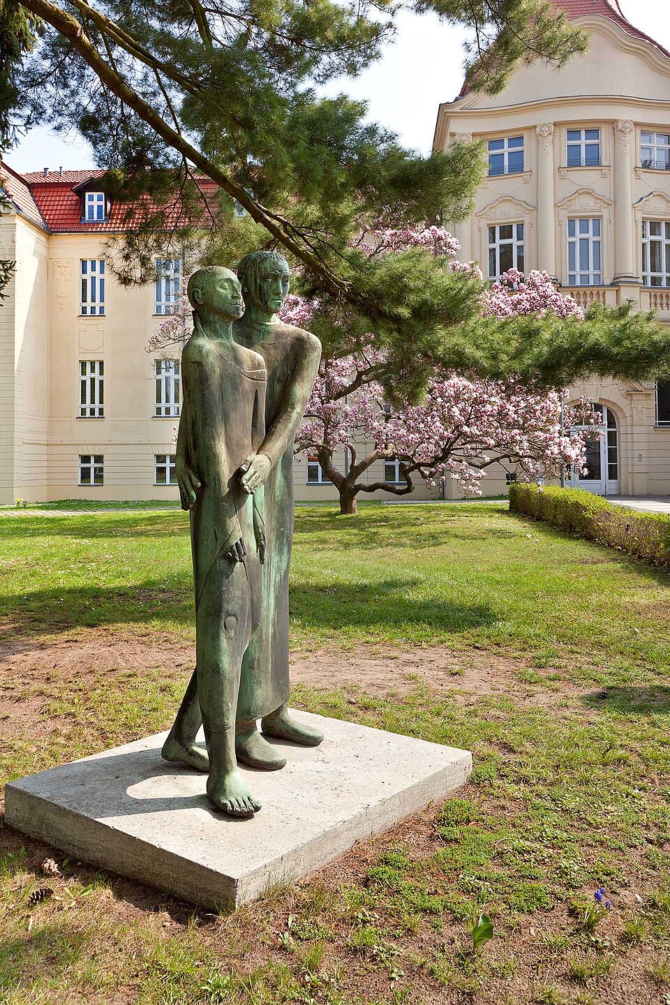 Bronzeplastik 'Der barmherzige Samariter' vor Gebäude