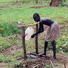 Mädchen in Uganda holt Wasser