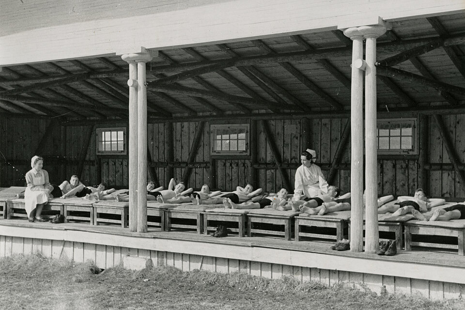 Historisches Foto: Schwestern beaufsichtigen Kinder beim Luftbaden