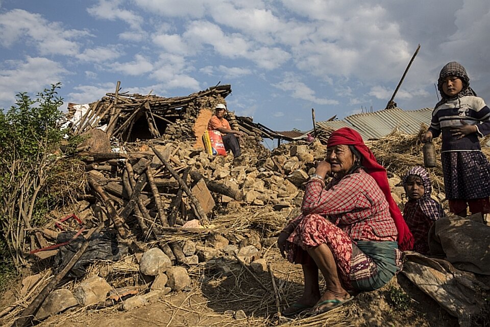 Nepalesische Frau vor Trümmern