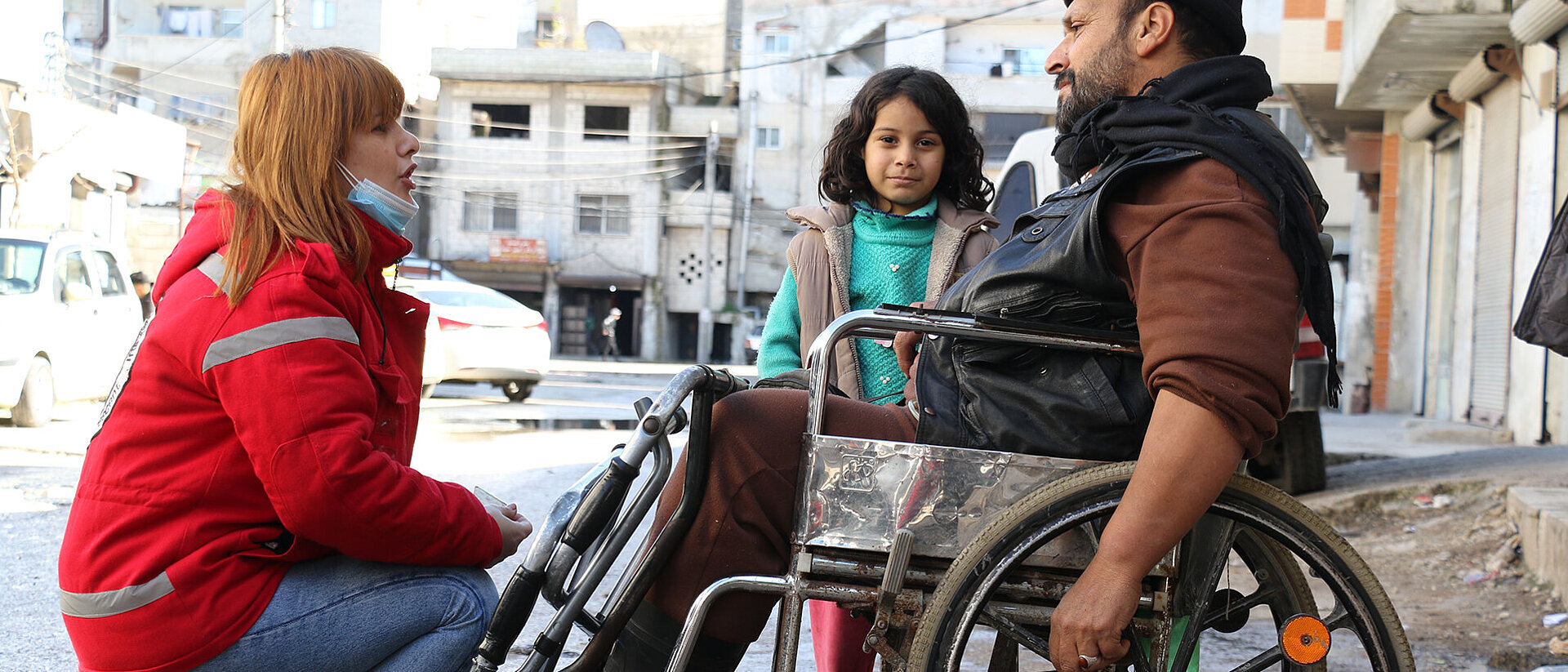 Volunteer speaking with man in wheelchair