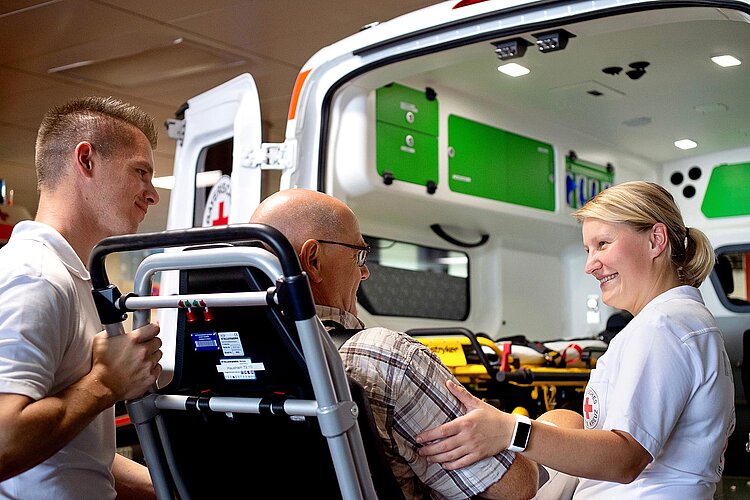 Rettungssanitäter mit Patienten am Rettungsfahrzeug
