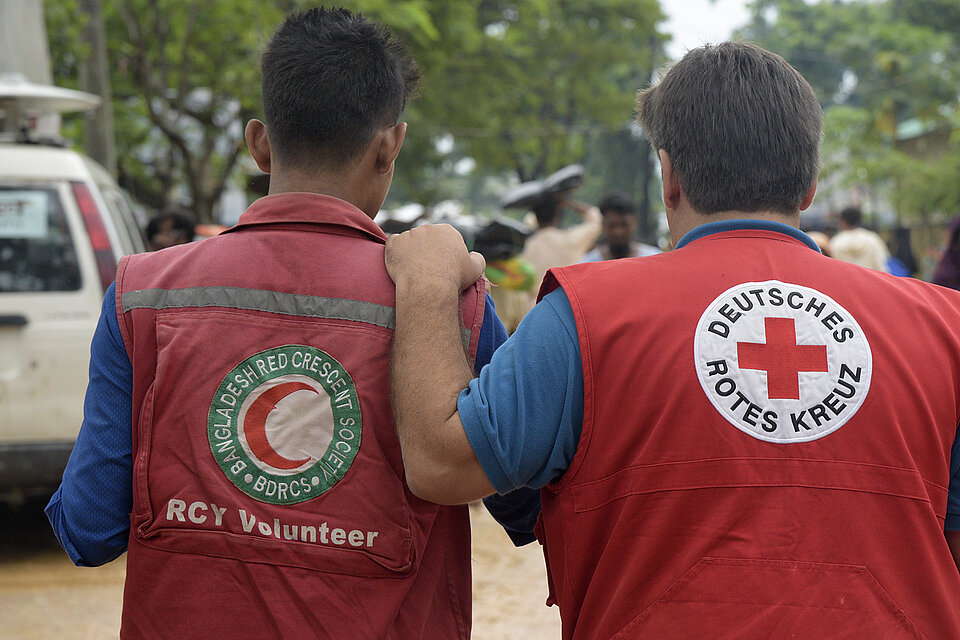 Rothalbmond-Freiwilliger und DRKler von hinten