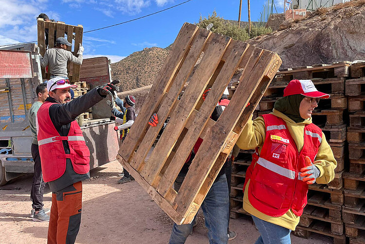 Helfer und Helferin mit Paletten zur Winterhilfe in Marokko 