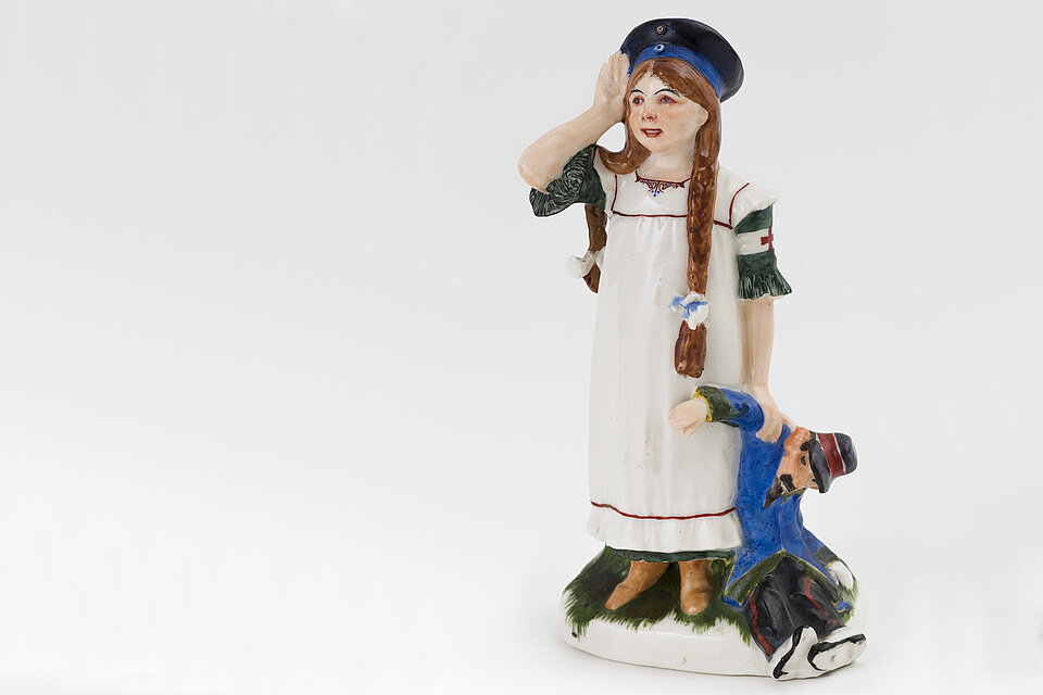 historische Porzellanfigur: Mädchen mit Rotkreuz-Armbinde
