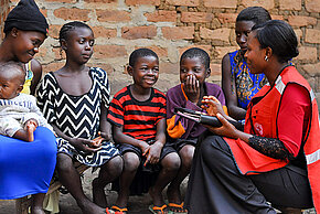 Rotkreuzlerin im Gespräch mit Familien in Uganda