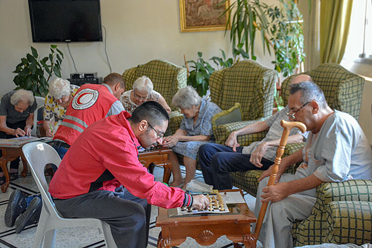 Foto: SARC-Helfer spielen Gesellschaftsspiele mit Senioren