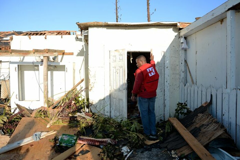 Mitarbeiter des Roten Kreuzes seht in einem zerstörten Haus nach Hurrikan Dorian