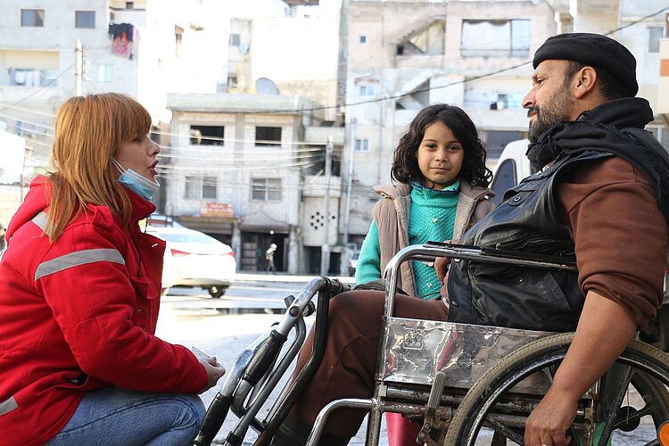 Volunteer with girl an man in wheelchair