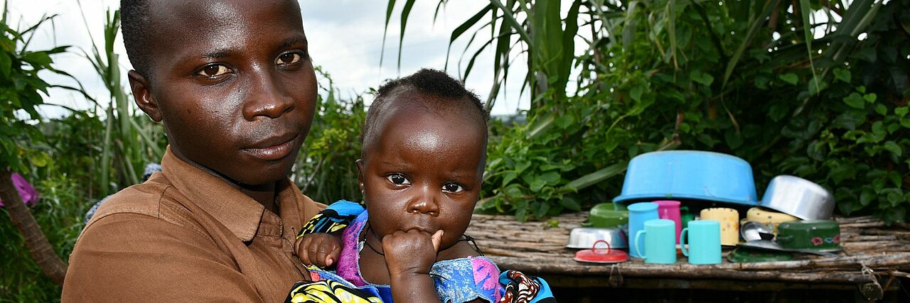 Flüchtling in Uganda mit Kleinkind im Arm