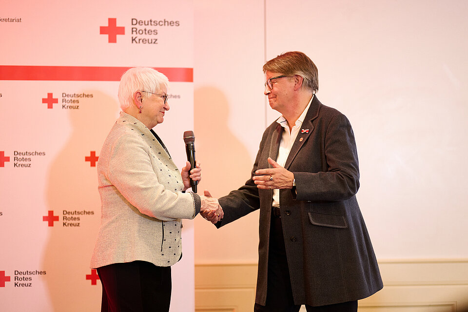 Gerda Hasselfeldt bei der Ernennung der ehemaligen Generaloberin des Verbandes der Schwesternschaften vom Roten Kreuz, Gabriele Müller-Stutzer, die beiden Frauen schütteln sich die Hände. 