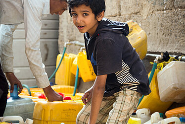 Foto: Jeminitischer Junge an einer Wasserausgabestelle