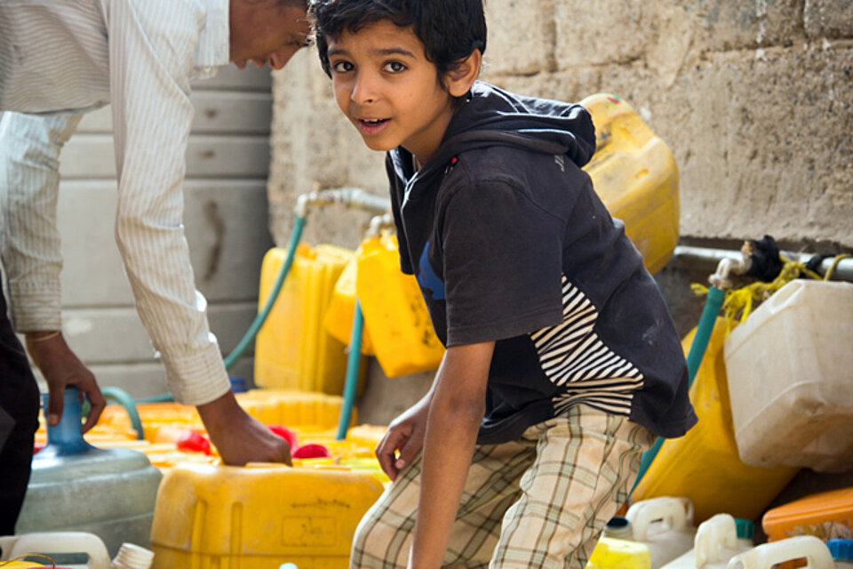 Jemenitischer Junge an einer Wasserausgabe
