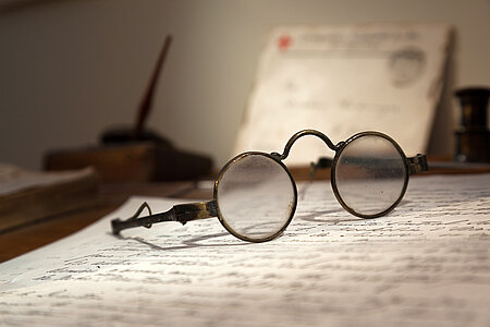 Dunants Brille und Brief auf seinem Schreibtisch
