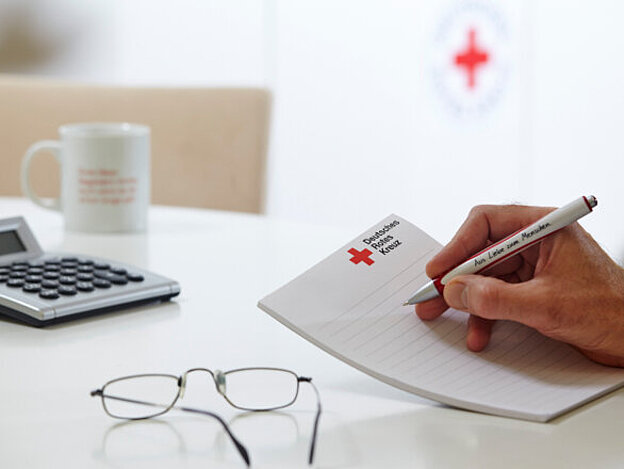 Deutsches Rotes Kreuz, DRK, Symbol, Symbolfoto, Taschenrechner, Tasse, Brille, Werbemittel, Büromaterial