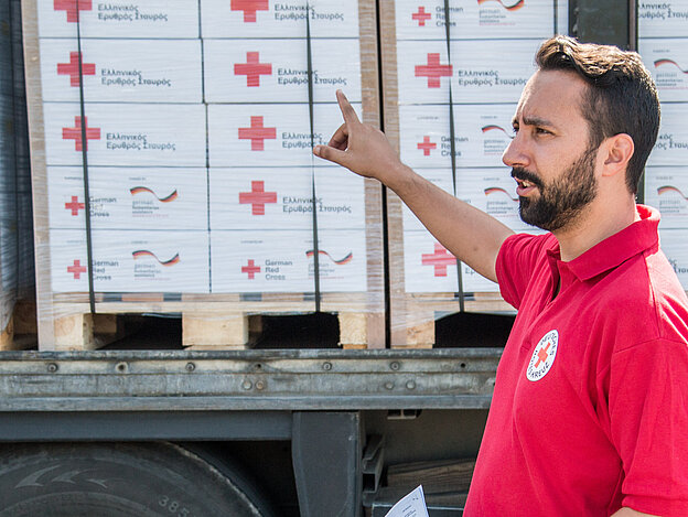 Volunteer in front of relief items