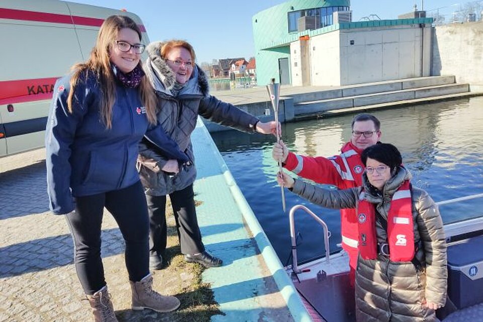 Die Übergabe der Fackel am Sperrwerk Greifswald-Wieck vom OV Greifswald an das Team des KV Rügen-Stralsund