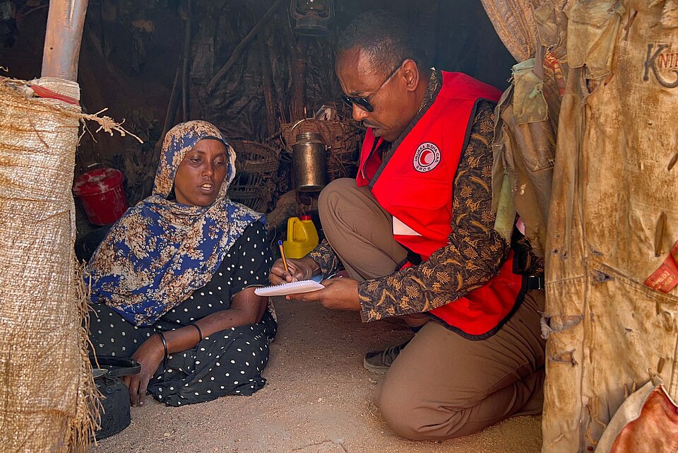 Somalierin und Rothalbmond-Helfer in Hütte