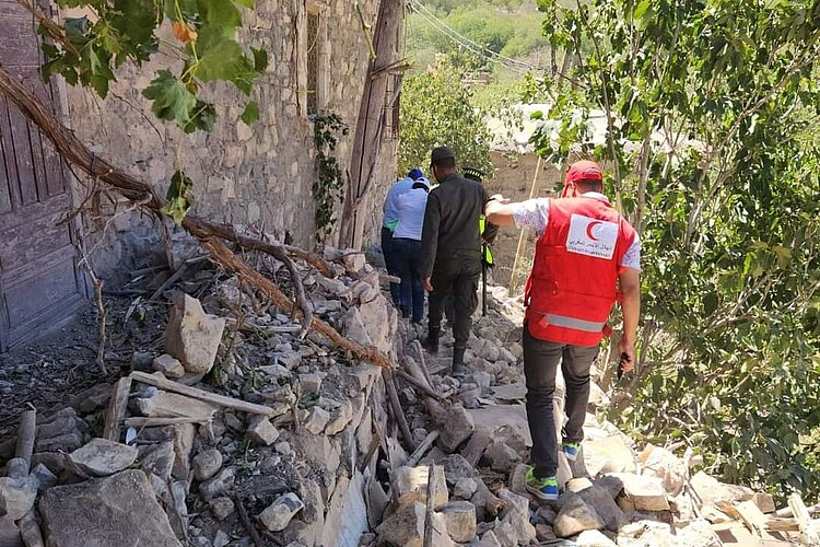 Ein Helfer des Marokkanischen Roten Halbmonds im Hilfseinsatz nahe einem zerstörten Gebäude.