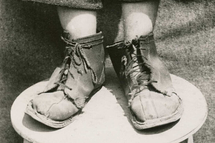 Nachkriegszeit in Deutschland: Ein Kind mit kaputten Schuhen im Lager Friedland (DRK)