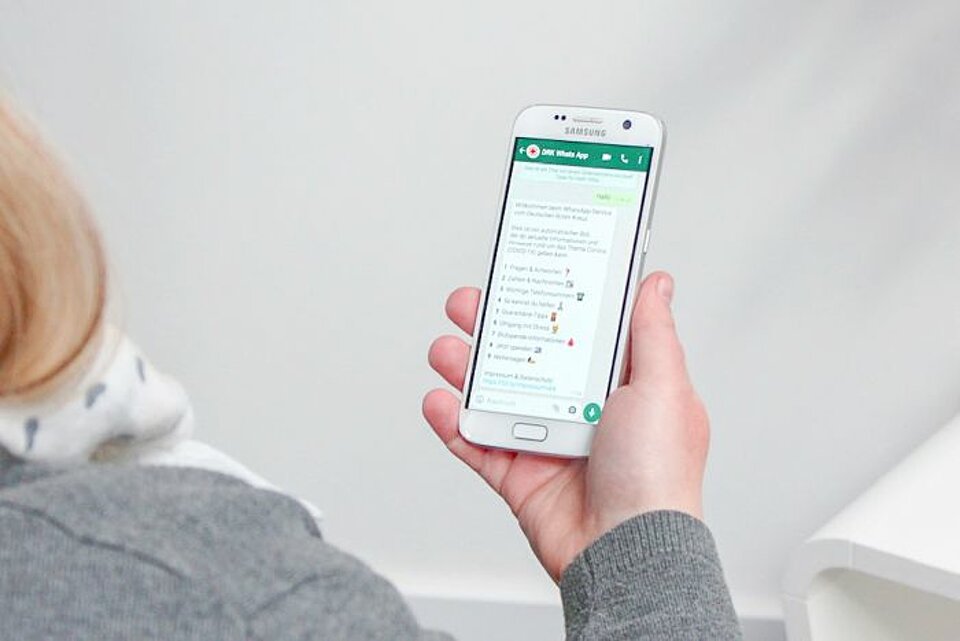 Smartphone mit DRK WhatsApp Chatbot für Coronavirus 