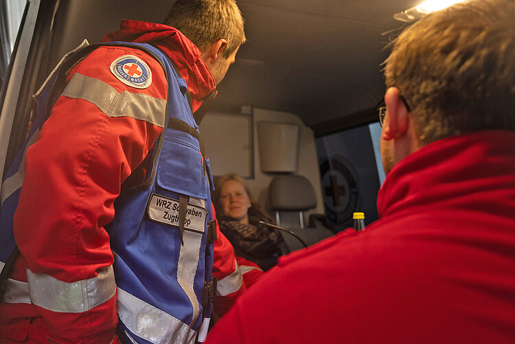 Rettungsteam mit evakuierter Frau während des Hochwassers in Bayern 2024 