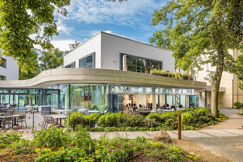 Ein modernes Gebäude mit Glasfassade in einem Garten