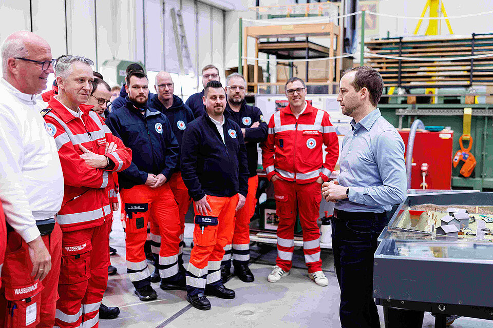 Zahlreiche Männer in DRK-Kleidung bei einem Lehrgang