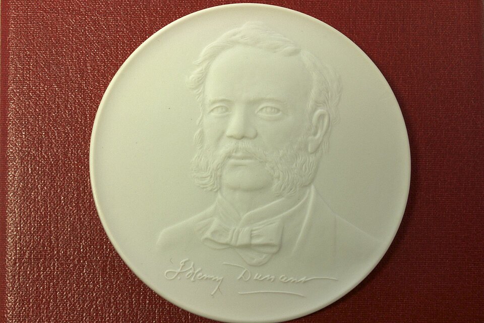 weiße Münze mit Bildnis von Henry Dunant