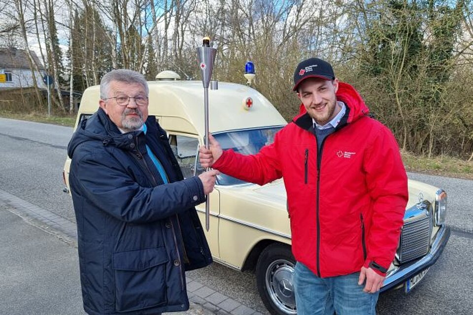 Jürgen Luig (li.), Präsident des DRK Lübeck, übernimmt das „Licht der Hoffnung“ von Florian Steinkamp vom DRK Schönberger Land.