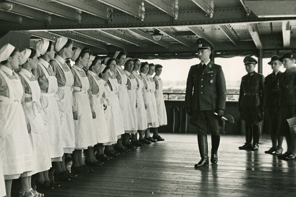 DRK-Schwestern in Reihe vor uniformiertem Mann