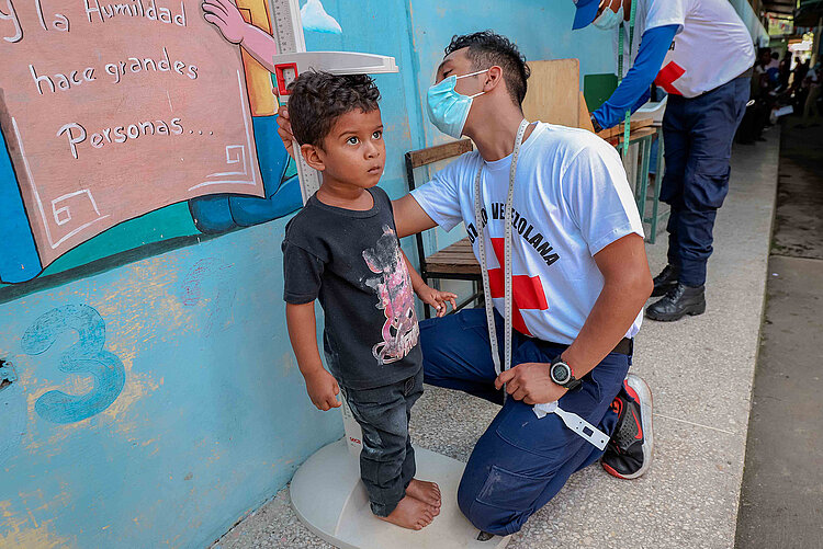 Junge wird gewogen in Venezuela