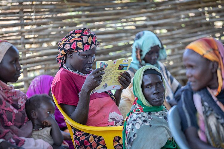 Junge Frau liest Flyer zu Müllmanagement