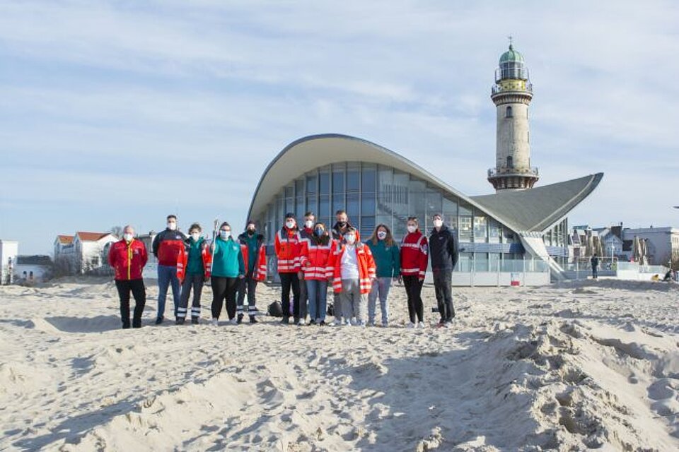 Ehrenamtliche des Jugendrotkreuzes, der Wasserwacht und der Bereitschaft am Leuchtturm in Warnemünde.