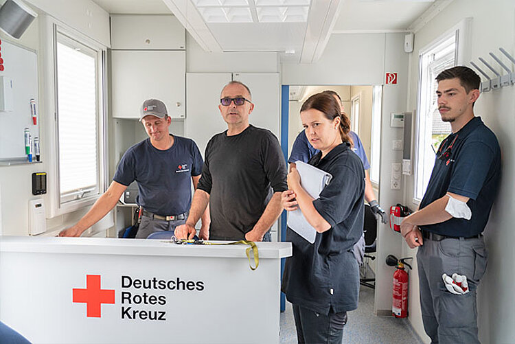 Arzt mit Helfern in der mobilen DRK-Klinik 