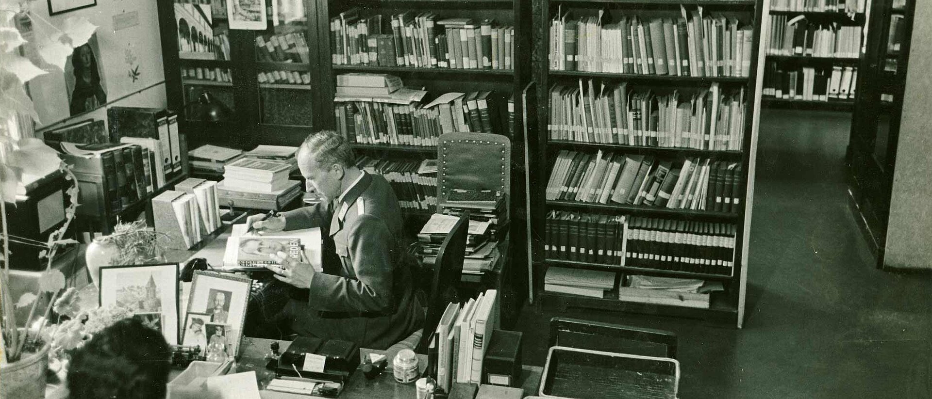 Mann in Raum mit Regalen voller Bücher