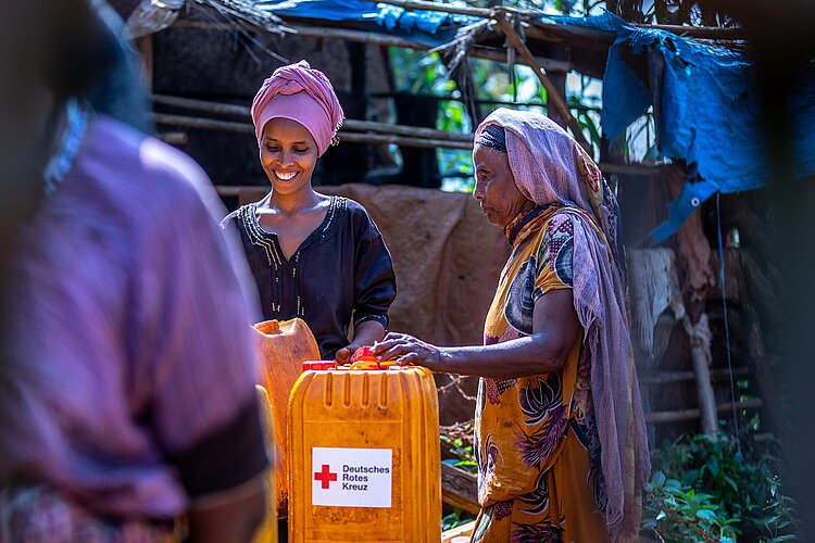 Zwei Frauen mit Wasserkanistern