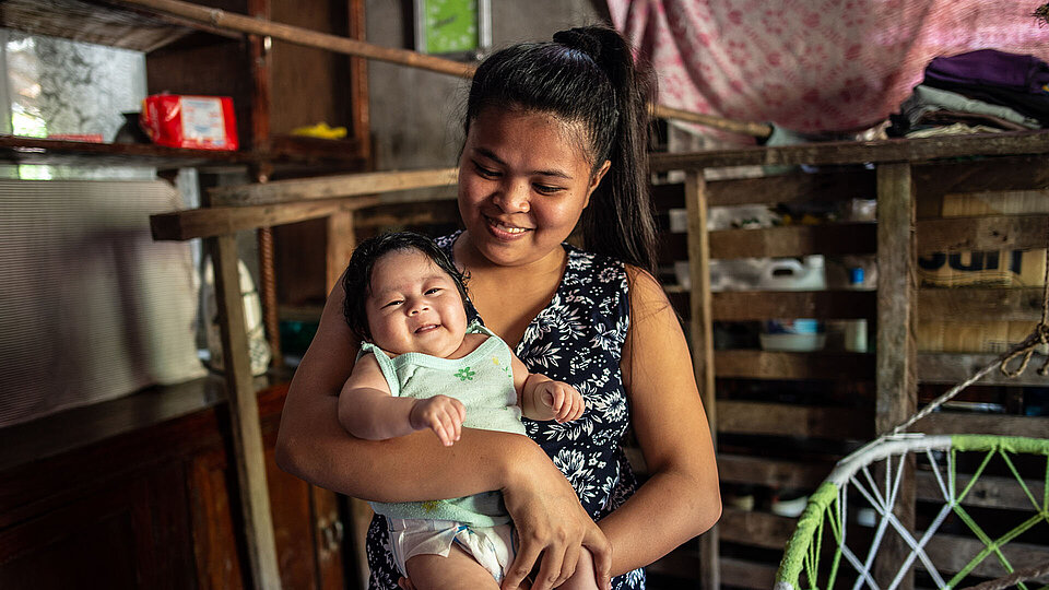 Philippinerin mit Baby im Arm
