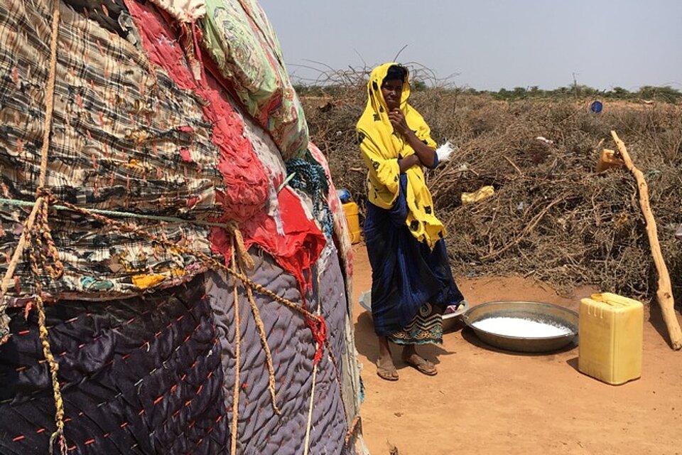 Somalische Frau vor Hütte