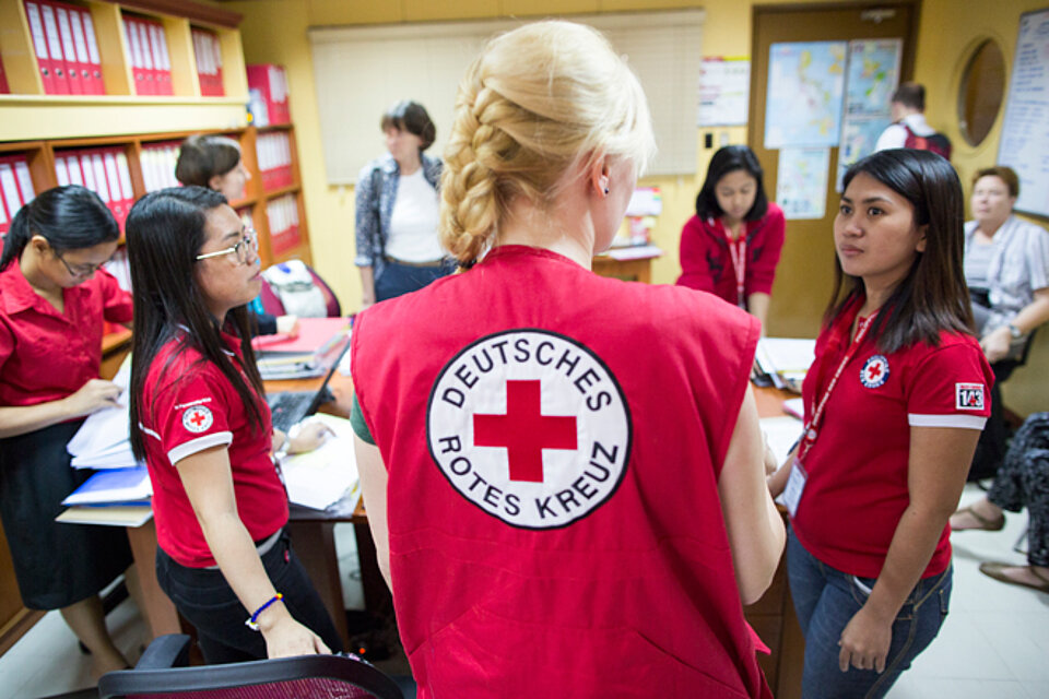 Foto: DRK-Mitarbeiterin im Gespräch mit philippinischen Helferinnen.